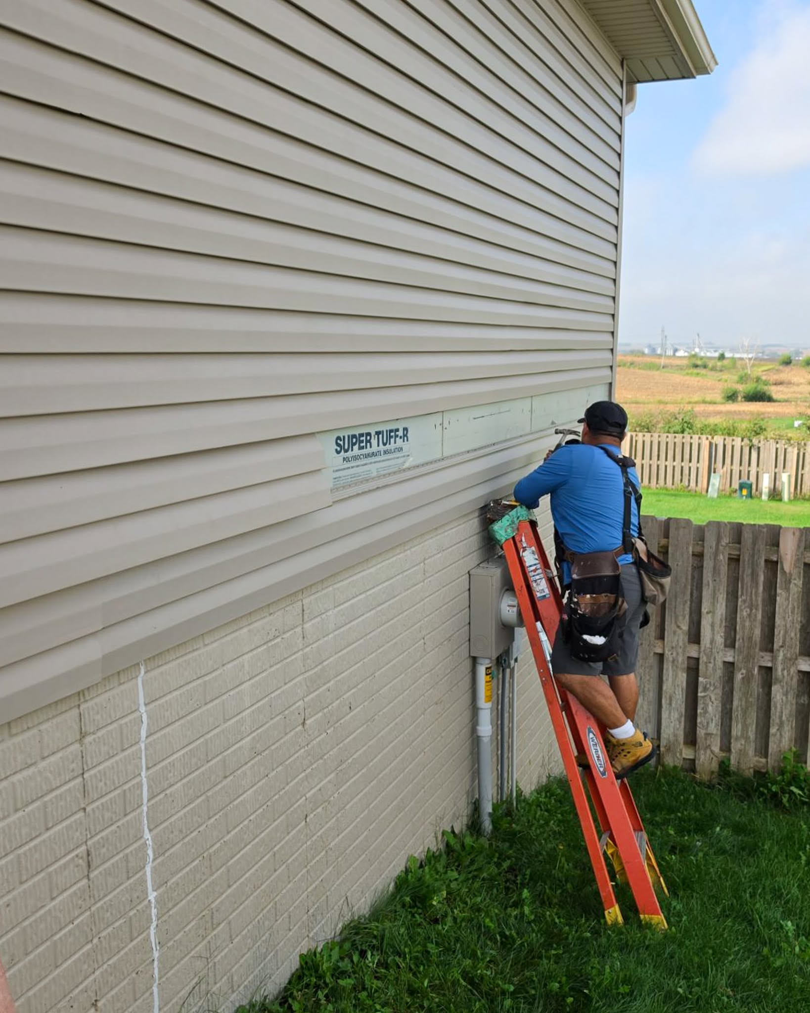 Siding Repair Omaha Contractor repairing siding and replacing insulation board during a siding repair project in Omaha, NE